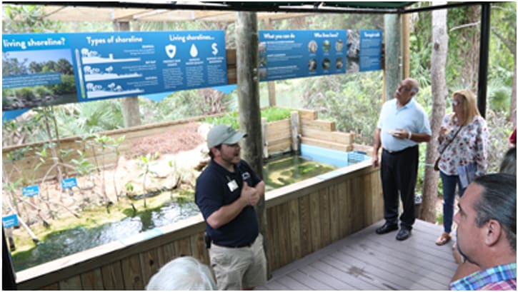 man providing educational chats to an audience standing around him