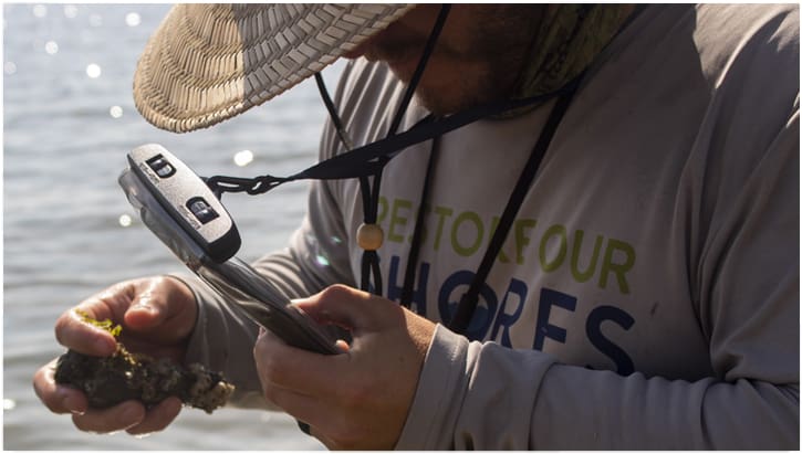 restore our shores man testing sample in his hand